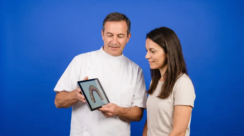 Zahnarzt zeigt einer Patientin das 3D-Setup auf einem Tablet